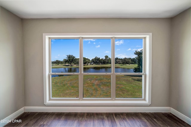 spare room featuring a water view and dark hardwood / wood-style flooring