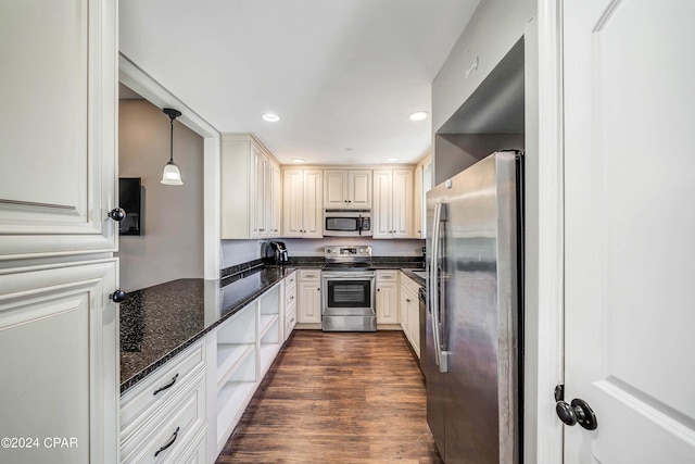 kitchen featuring pendant lighting, dark stone counters, dark hardwood / wood-style floors, white cabinets, and stainless steel appliances