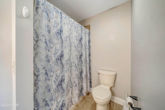 bathroom with a shower with curtain, tile patterned floors, and toilet