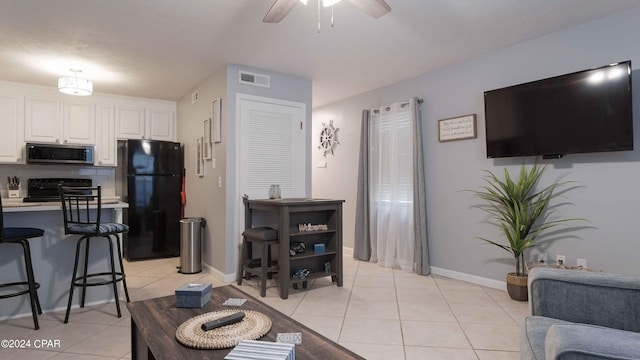 living room with ceiling fan and light tile patterned flooring