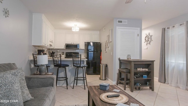 living room featuring light tile patterned flooring and ceiling fan