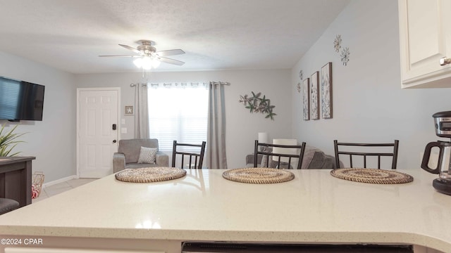 tiled dining room featuring a textured ceiling and ceiling fan