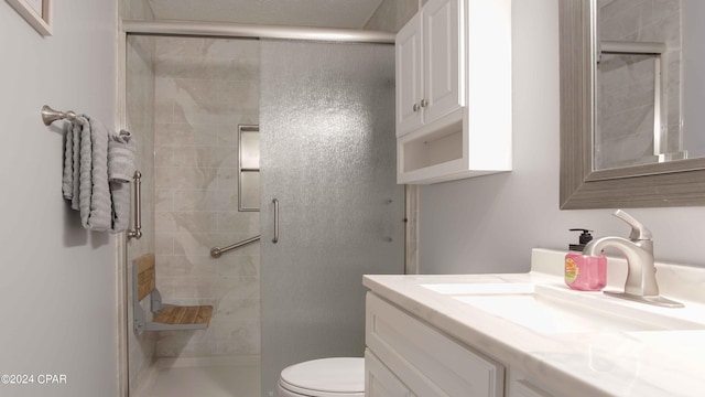 bathroom featuring vanity, toilet, and a shower with shower door