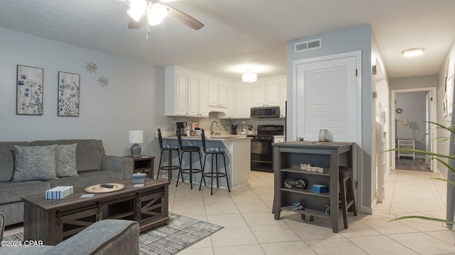 living room with light tile patterned floors, sink, and ceiling fan