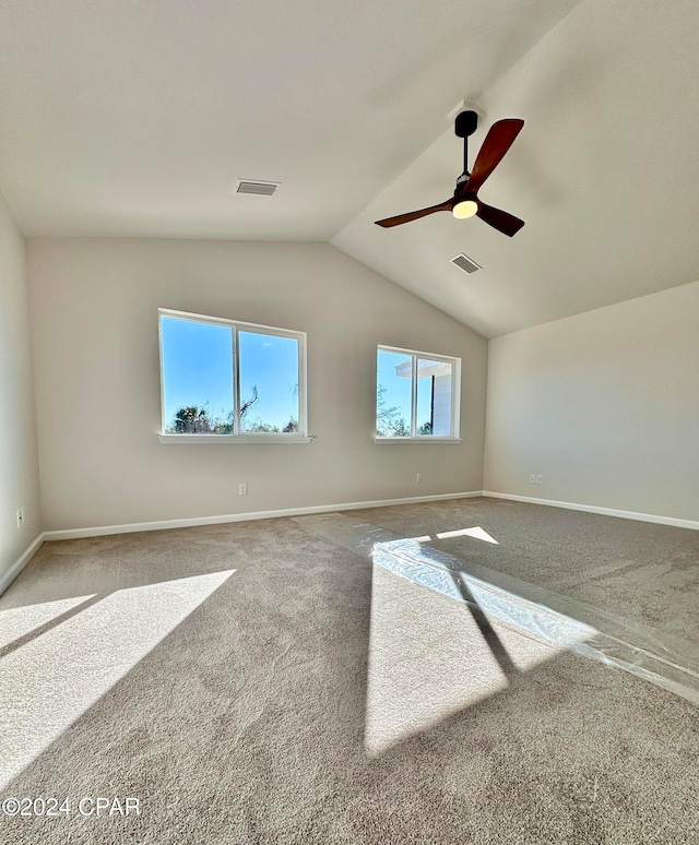 unfurnished room featuring ceiling fan, vaulted ceiling, and carpet