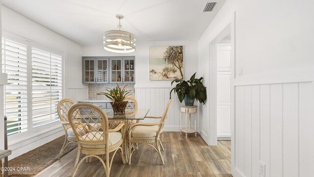 dining space with light hardwood / wood-style flooring and an inviting chandelier