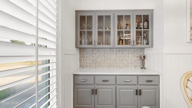 bar with gray cabinets and backsplash