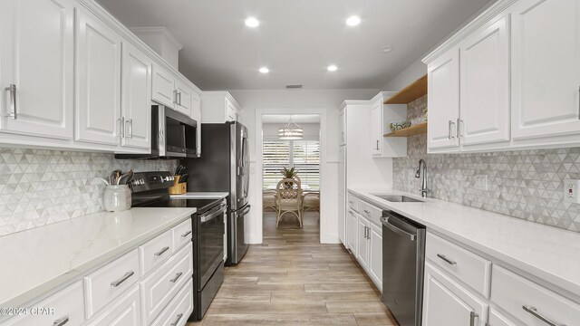 kitchen with white cabinets, stainless steel appliances, light wood-type flooring, and sink