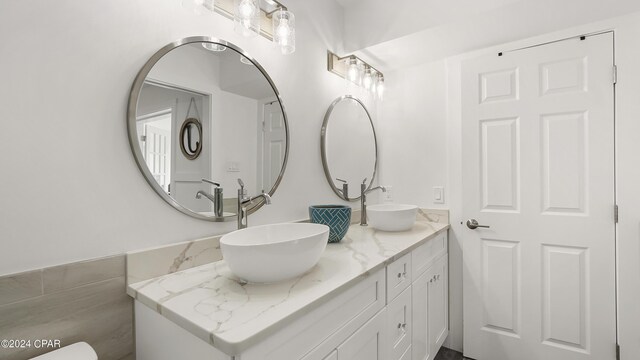 bathroom with vanity and tile walls