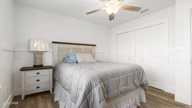 bedroom with a closet, wood-type flooring, and ceiling fan