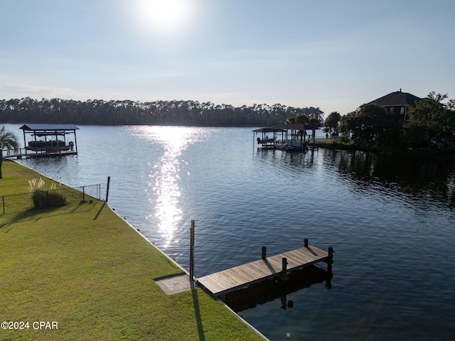 view of dock featuring a lawn and a water view