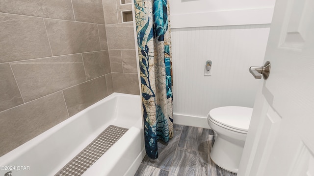 bathroom with shower / bathtub combination with curtain, hardwood / wood-style floors, and toilet