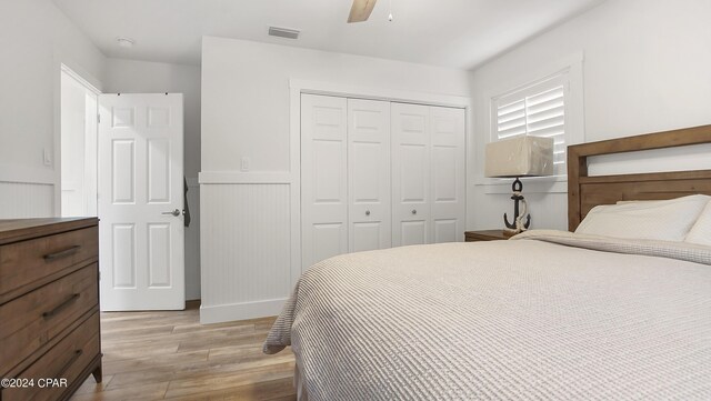 bedroom with light wood-type flooring, a closet, and ceiling fan