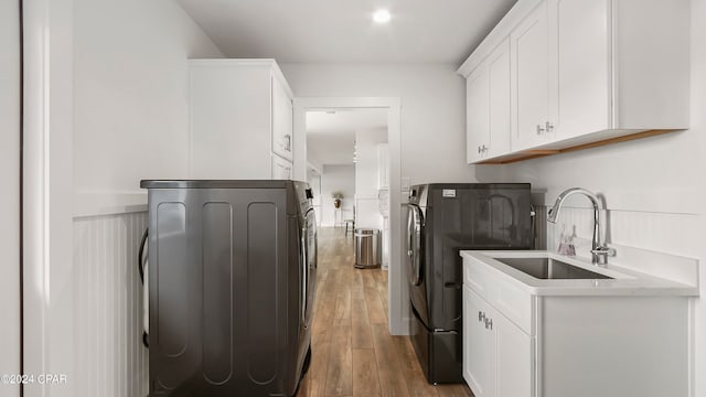 laundry room with cabinets, sink, dark wood-type flooring, and washing machine and dryer