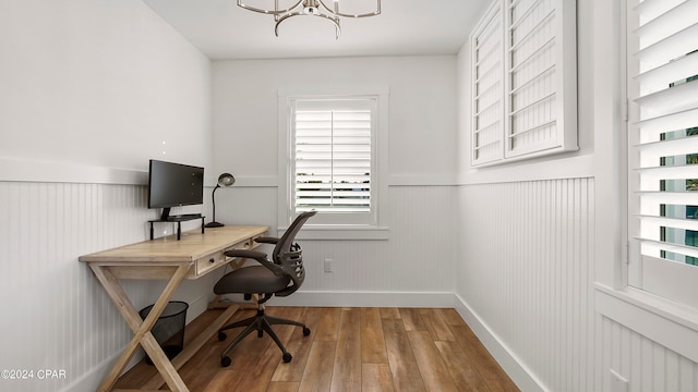 office featuring wood-type flooring and an inviting chandelier