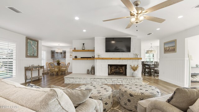 living room featuring a fireplace, hardwood / wood-style floors, and ceiling fan