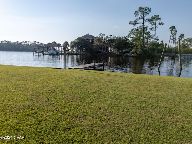 dock area with a lawn and a water view