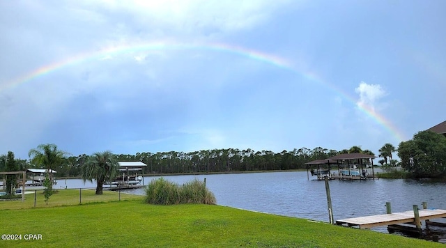 view of dock featuring a water view and a yard