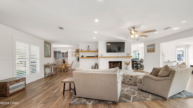 living room with a fireplace, hardwood / wood-style floors, and ceiling fan