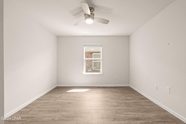 spare room with ceiling fan and light wood-type flooring