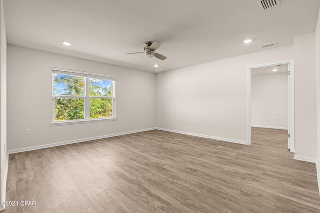 unfurnished room featuring ceiling fan, a textured ceiling, and light wood-type flooring