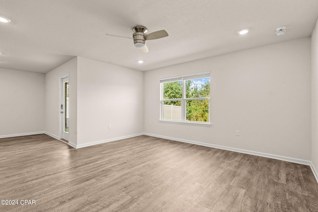 spare room with wood-type flooring, ceiling fan, and a textured ceiling