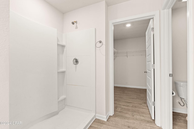 bathroom with walk in shower, hardwood / wood-style flooring, and toilet