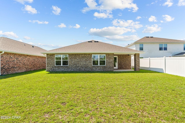 back of house with a lawn and a patio