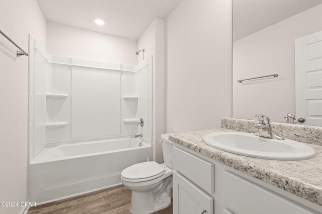 full bathroom featuring hardwood / wood-style floors, bathing tub / shower combination, vanity, and toilet