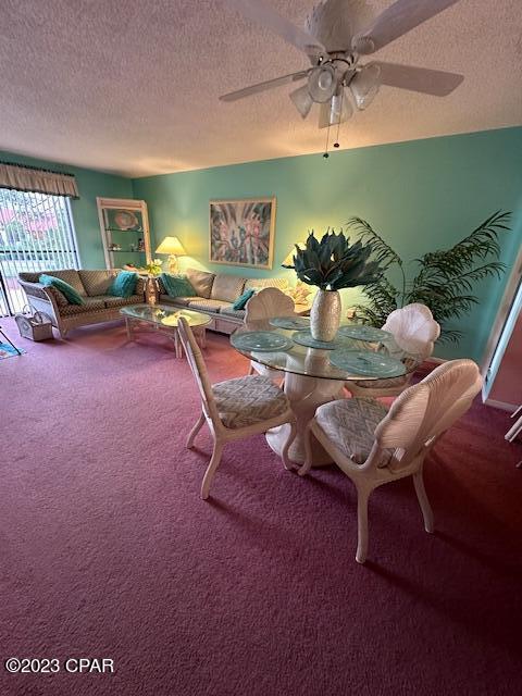 dining area featuring a textured ceiling, carpet flooring, and ceiling fan