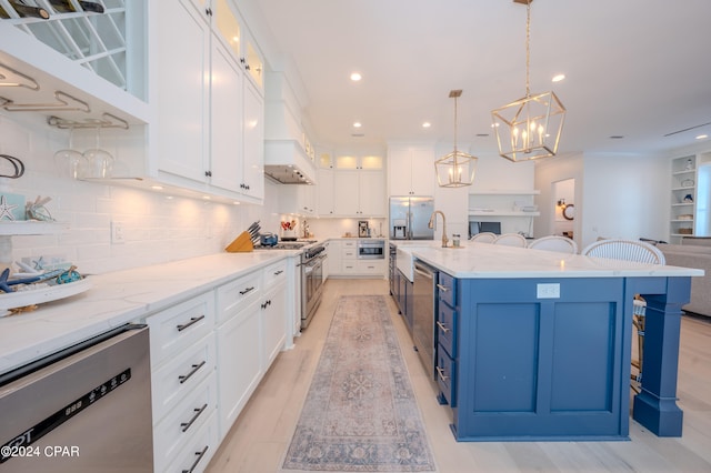 kitchen featuring a large island, a breakfast bar, white cabinets, hanging light fixtures, and appliances with stainless steel finishes