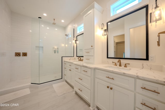 bathroom with vanity, hardwood / wood-style flooring, and tiled shower