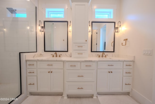 bathroom featuring a wealth of natural light, a shower with door, and vanity