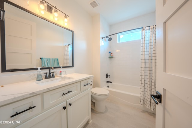 full bathroom with wood-type flooring, shower / tub combo with curtain, vanity, and toilet