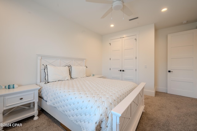 carpeted bedroom with ceiling fan and a closet