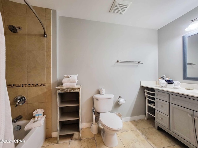 full bathroom featuring tile patterned flooring, vanity, tiled shower / bath combo, and toilet