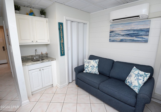 living room featuring wooden walls, wet bar, light tile patterned floors, and a wall unit AC