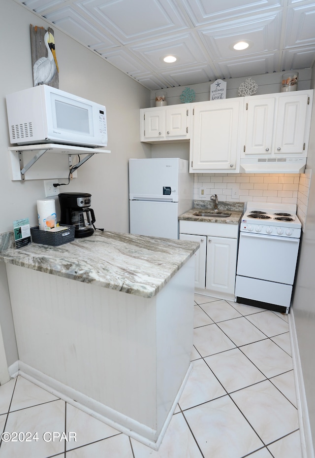 kitchen with decorative backsplash, sink, white appliances, and white cabinetry