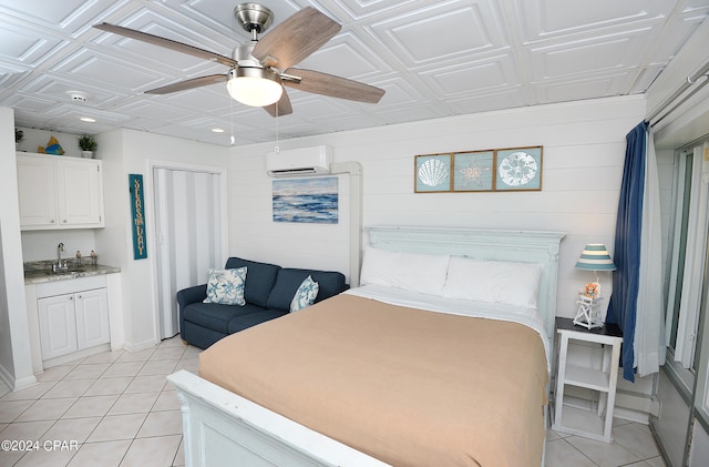 tiled bedroom featuring ceiling fan, indoor wet bar, coffered ceiling, and an AC wall unit