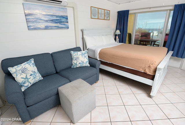 bedroom with a wall unit AC and tile patterned floors