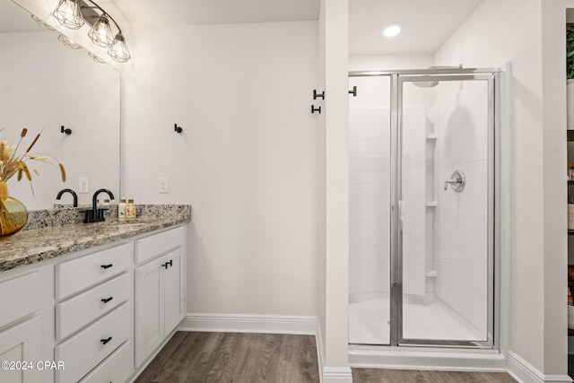 bathroom with vanity, a shower with door, and hardwood / wood-style flooring