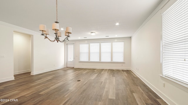 interior space featuring an inviting chandelier, crown molding, and dark hardwood / wood-style flooring