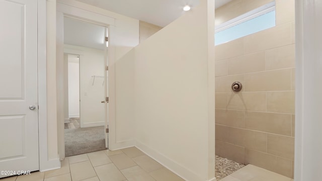 bathroom featuring tile patterned flooring and a tile shower