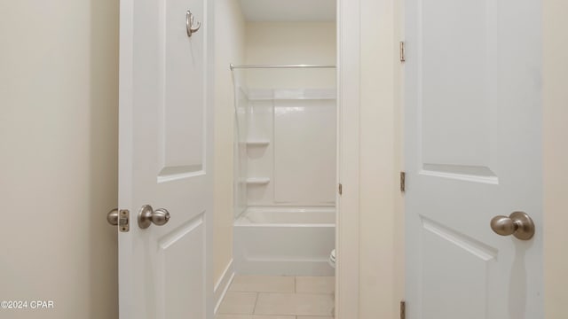 bathroom with tile patterned flooring, toilet, and bathtub / shower combination