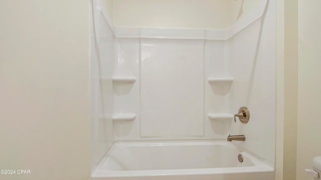 bathroom featuring shower / washtub combination and toilet