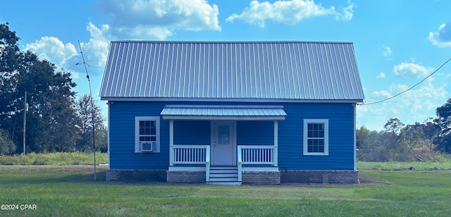 view of front of property with metal roof, a porch, and a front yard