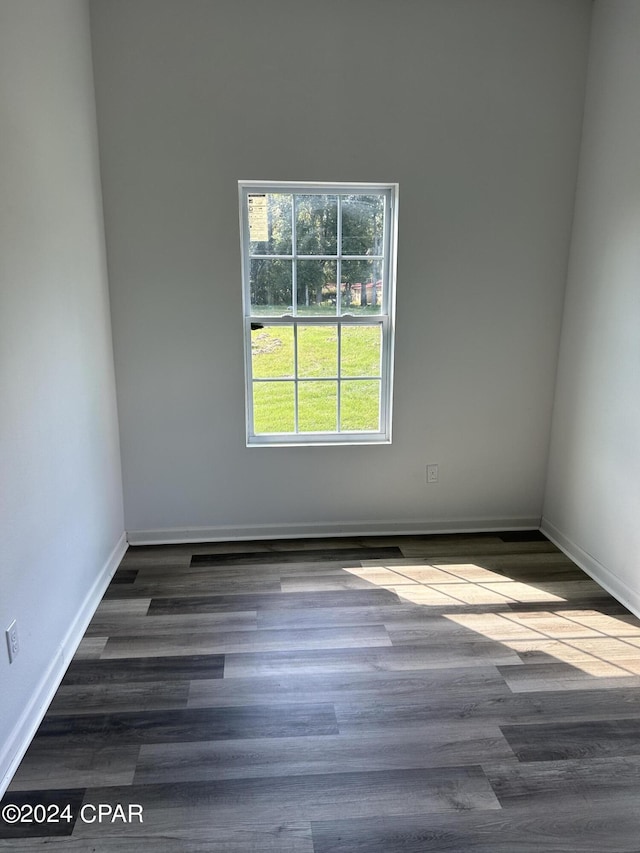 unfurnished room with baseboards and wood finished floors