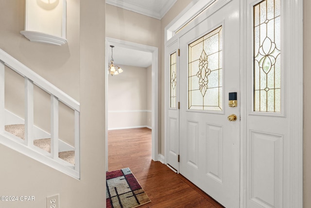 entrance foyer featuring crown molding, dark hardwood / wood-style floors, and a chandelier