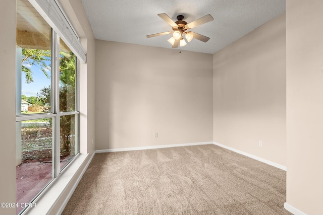 carpeted spare room with a textured ceiling and ceiling fan