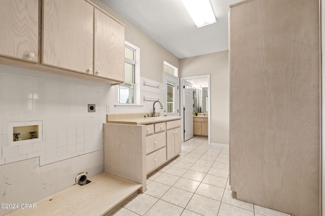 washroom with cabinets, sink, electric dryer hookup, light tile patterned floors, and hookup for a washing machine